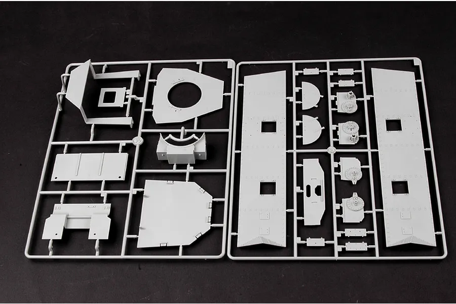 Two grey plastic model kit sprues containing various flat and shaped armoured locomotive parts for a 1/35 scale model.