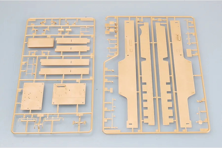 Two tan plastic model kit sprues containing various flat panels and structural components for a military vehicle model.