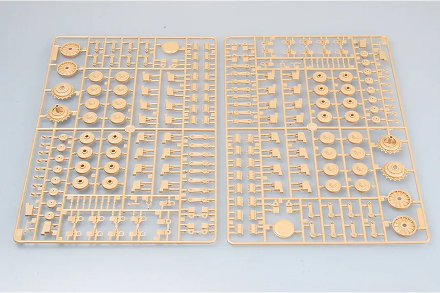 Two tan plastic model kit sprues featuring various wheels, suspension arms, and small mechanical parts for a military vehicle model.