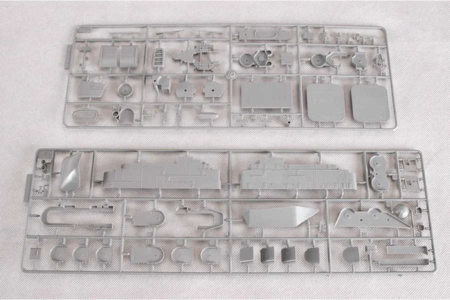 Two grey plastic model kit sprues containing various ship parts laid out on a white surface.