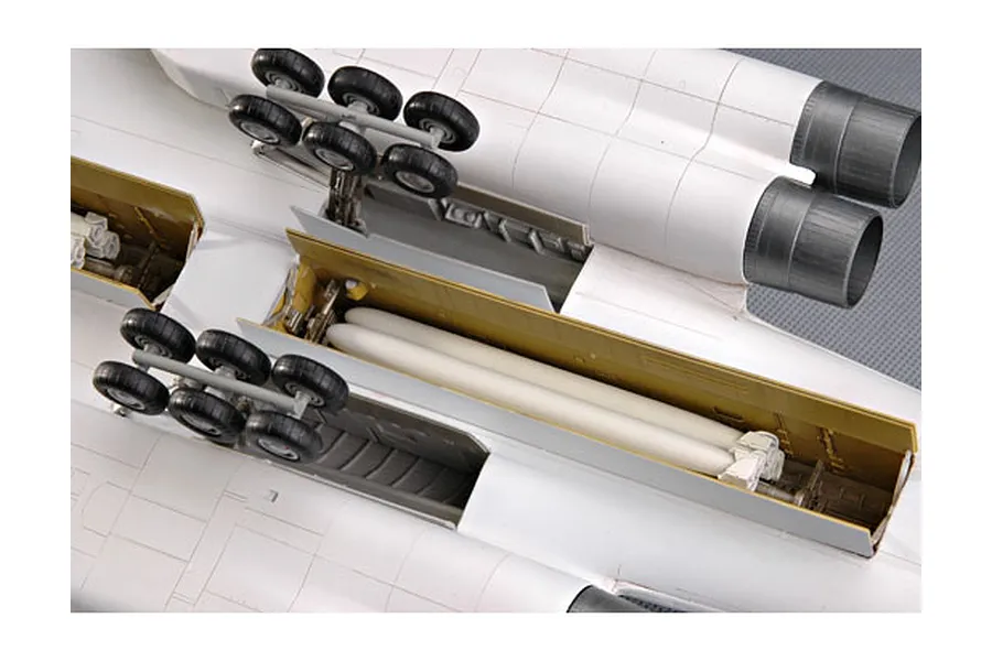 Underside view of a 1/72 scale plastic model TU-160 bomber showing landing gear and open weapons bay with missiles.
