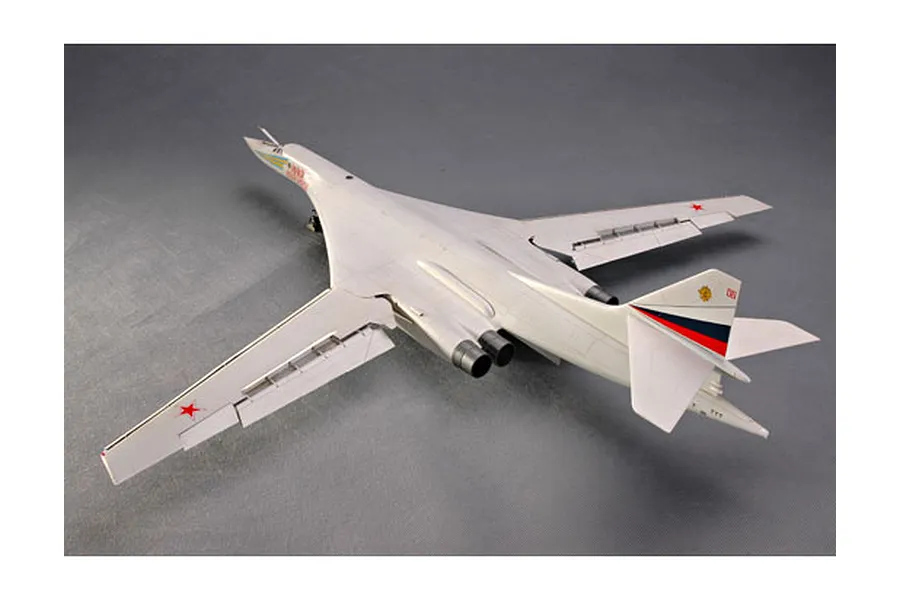 A high-angle view of a finished 1/72 scale plastic model of a Tupolev Tu-160 Blackjack bomber jet, featuring white fuselage and swept-back wings.