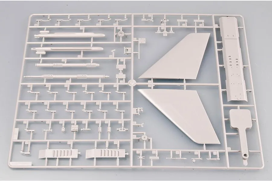 A grey plastic model kit sprue containing various aircraft parts including wing sections and cylindrical components for a Trumpeter model.
