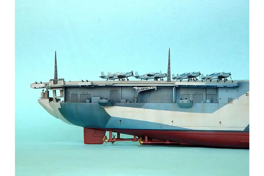 A side-profile view of a detailed 1/350 scale plastic model of the USS Yorktown aircraft carrier, showing the flight deck with parked aircraft.