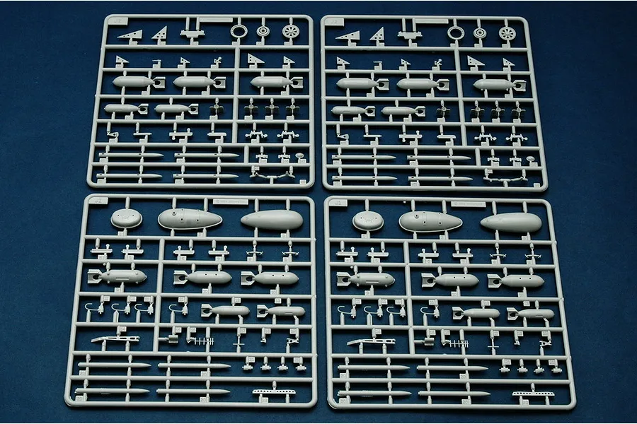Four grey plastic model kit sprues containing various bomb and missile parts for a 1/32 scale aircraft model.