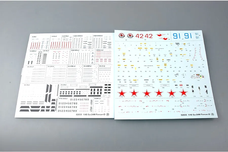 Two decal sheets for a 1/48 scale Trumpeter Su-24M Fencer-D model kit, featuring various markings, numbers, and red star insignias.