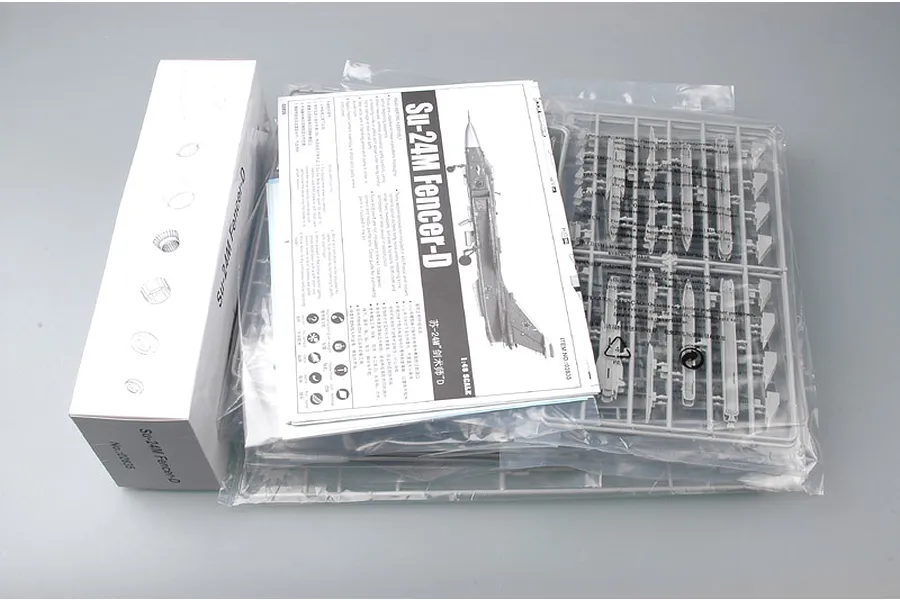 Trumpeter 1/48 scale Su-24M Fencer-D model kit contents including a white box, instruction manual, and plastic sprues in sealed bags.
