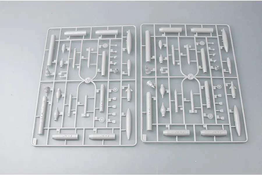 Two identical grey plastic model kit sprues containing various aircraft parts and missile components on a plain grey background.