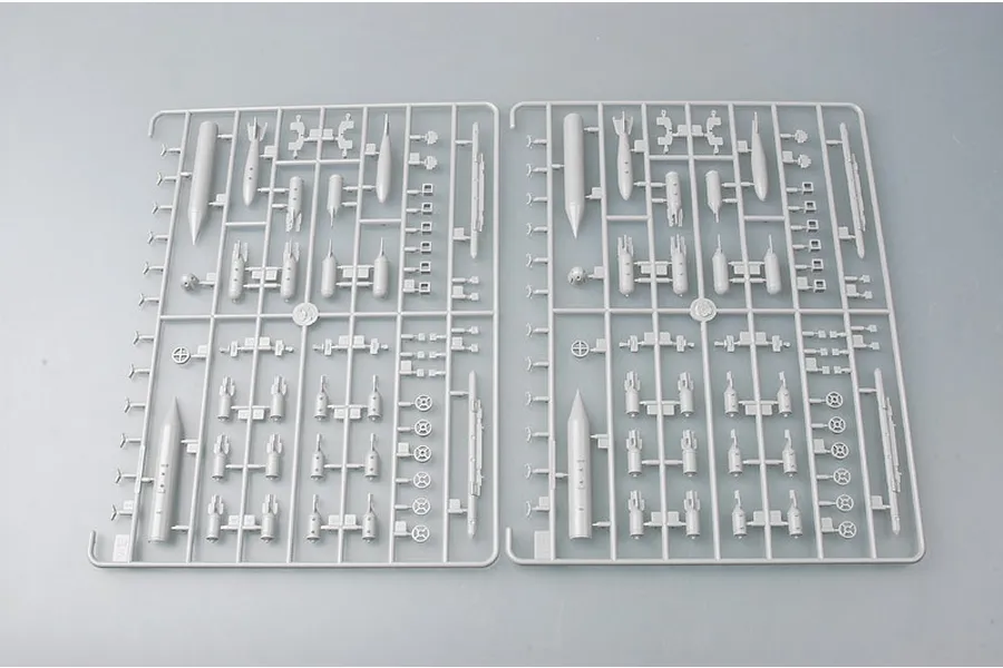 Two identical grey plastic model kit sprues containing various aircraft weapon parts like bombs and missiles.