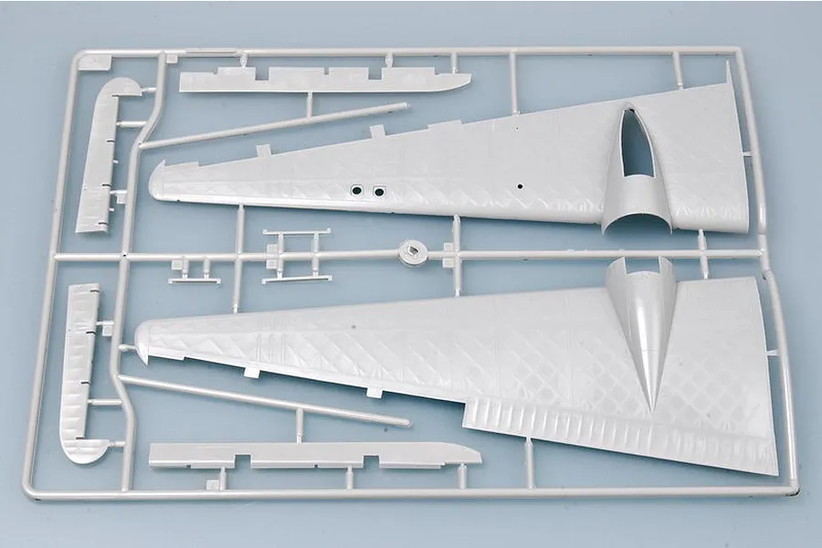 A grey plastic sprue from a model kit containing two large aircraft wing sections and smaller control surface parts.