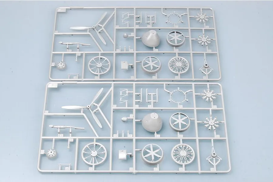 Two identical grey plastic model kit sprues containing aircraft engine parts, propellers, and wheel components on a light grey background.