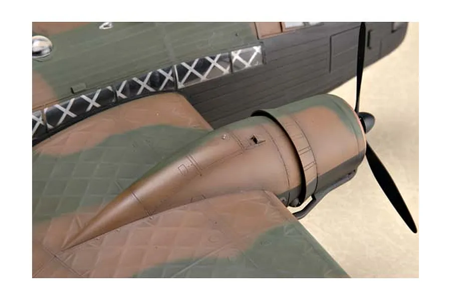 Close-up of a plastic model aircraft wing and engine nacelle with camouflage paint, showing the geodetic structure detail.