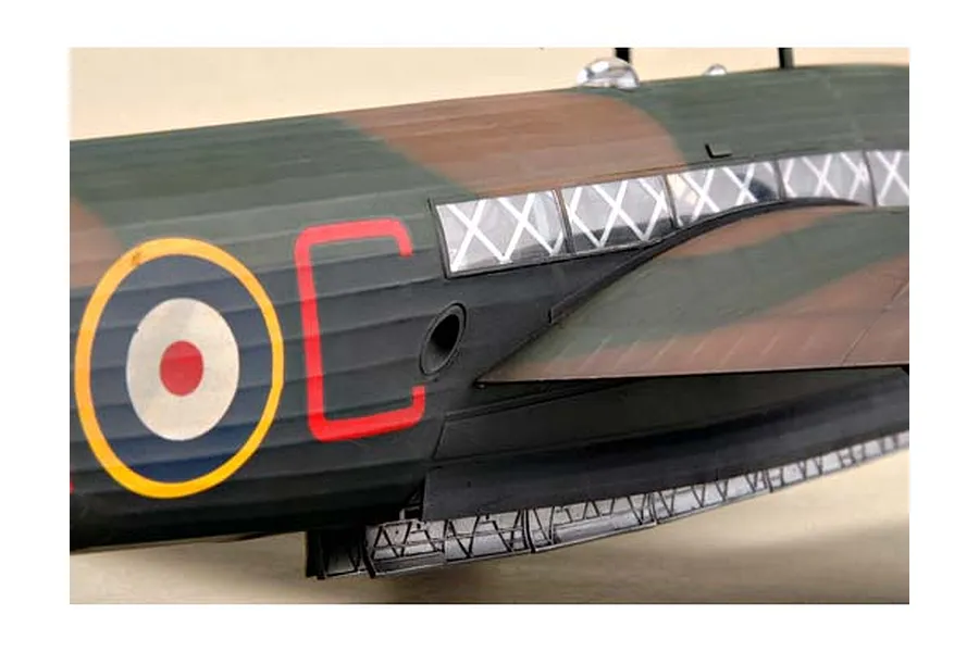 Close-up of a 1/48 scale model Wellington bomber showing the fuselage with camouflage paint, RAF roundel, and side windows.