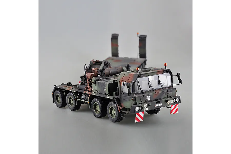 A 1/35 scale plastic model of a German Faun SLT-56 tank transporter truck in camouflage paint, shown from a high-angle front three-quarter view.