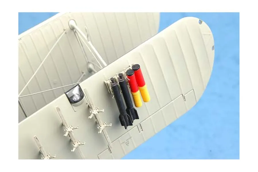 Close-up of a 1/32 scale Fairey Swordfish model aircraft wing showing mounted black bombs and red and yellow practice bombs.