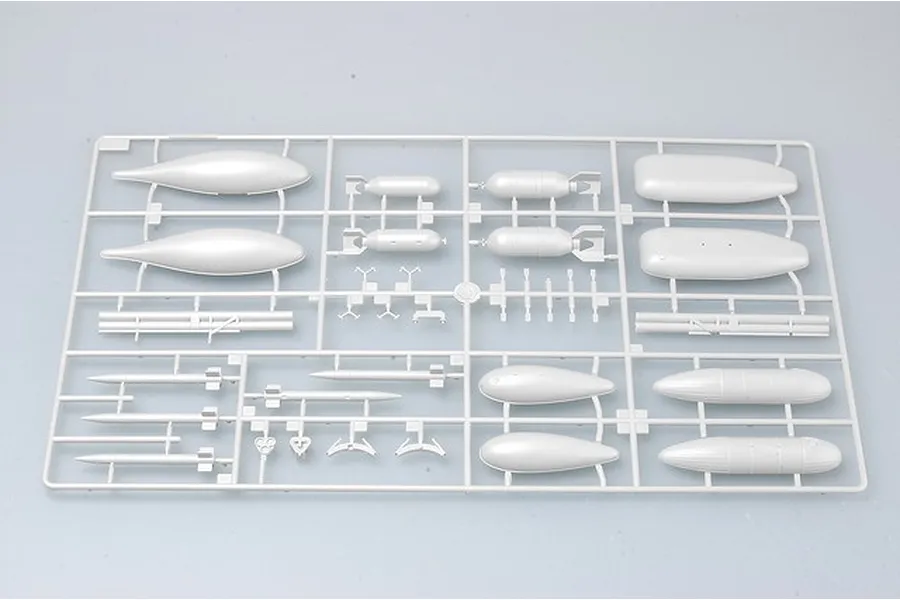 A grey plastic sprue containing various model aircraft parts including bombs, fuel tanks, and missiles for a 1/32 scale model kit.