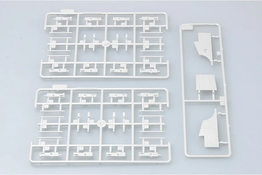 Three grey plastic model kit sprues containing aircraft parts on a light grey background.