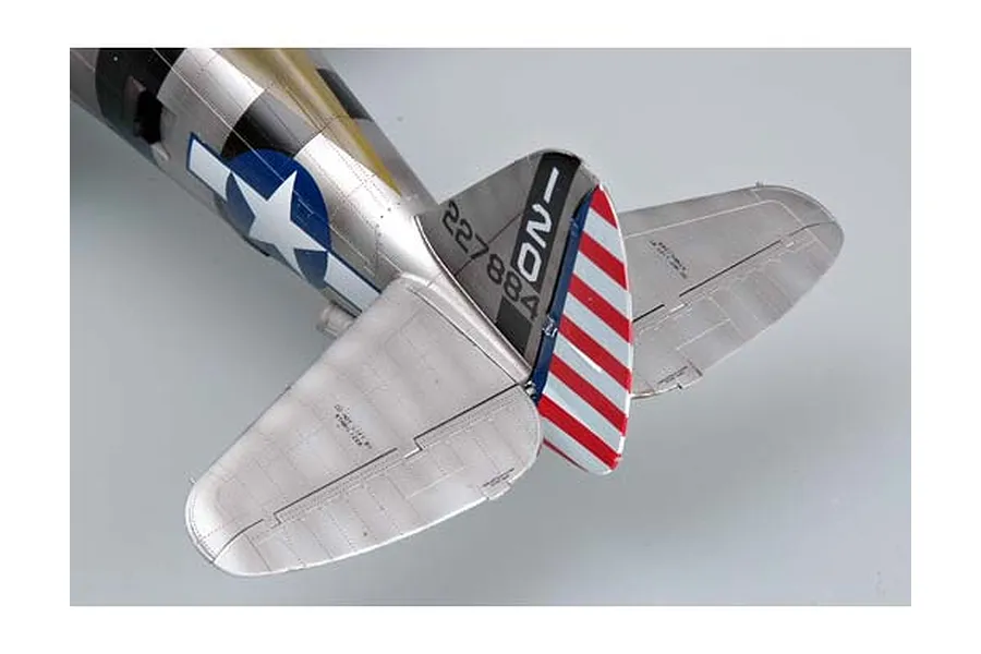 Close-up of the tail section of a 1/32 scale P-47 Thunderbolt model, showing silver fuselage, red and white striped rudder, and US military insignia.