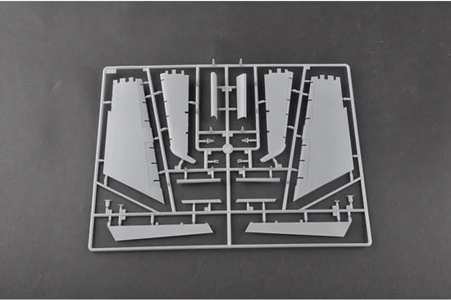 A grey plastic sprue containing various aircraft wing and control surface parts for a model kit.