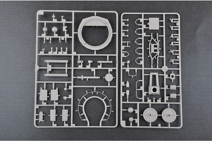 Two grey plastic model kit sprues containing various parts for a 1/35 scale military vehicle model, laid out on a dark grey surface.