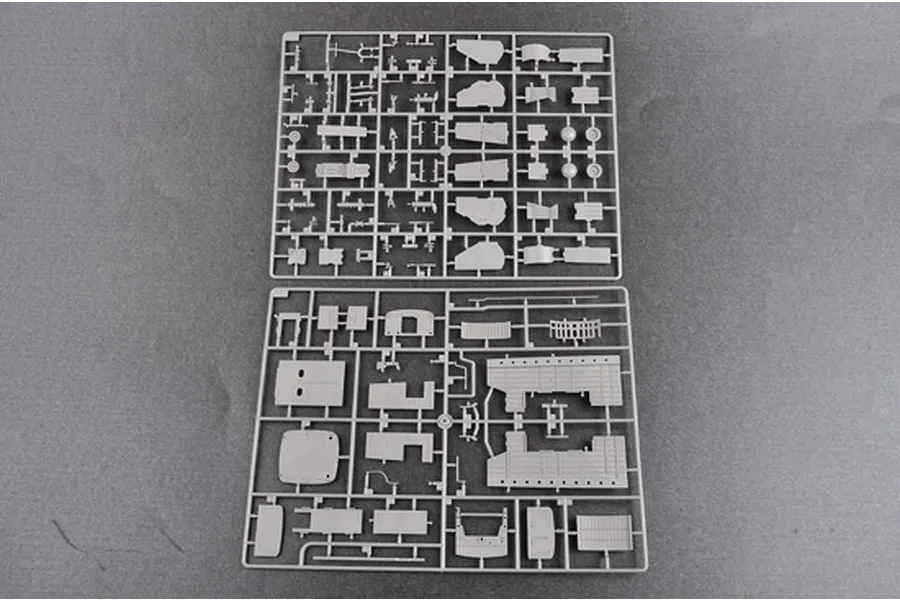 Two grey plastic model kit sprues containing various aircraft parts laid out on a flat grey surface.