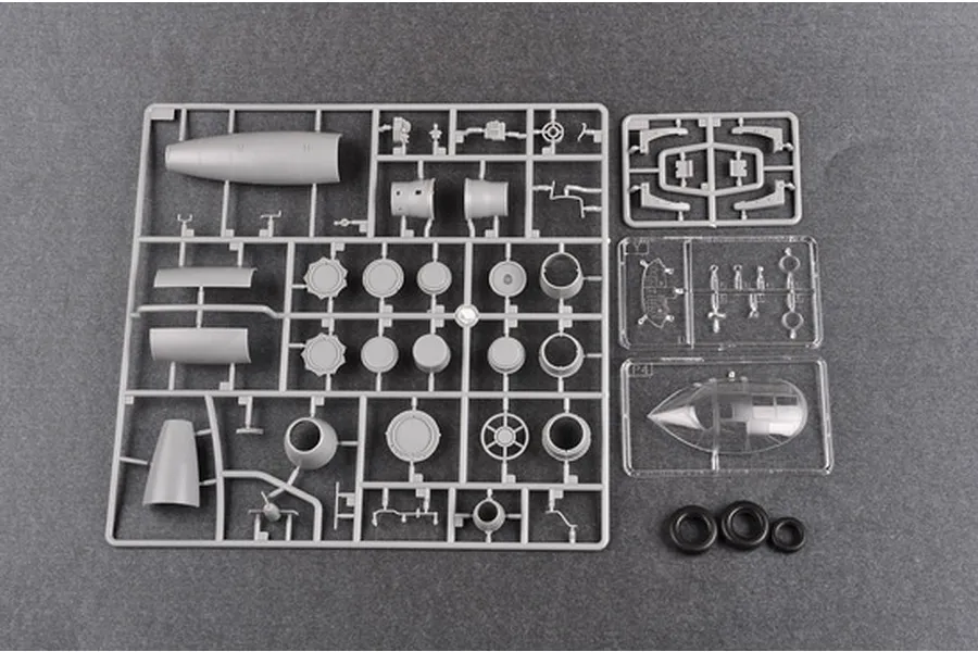 Plastic model kit sprues for a Trumpeter 1/48 scale aircraft model, including grey plastic parts, clear canopy pieces, and rubber tires.