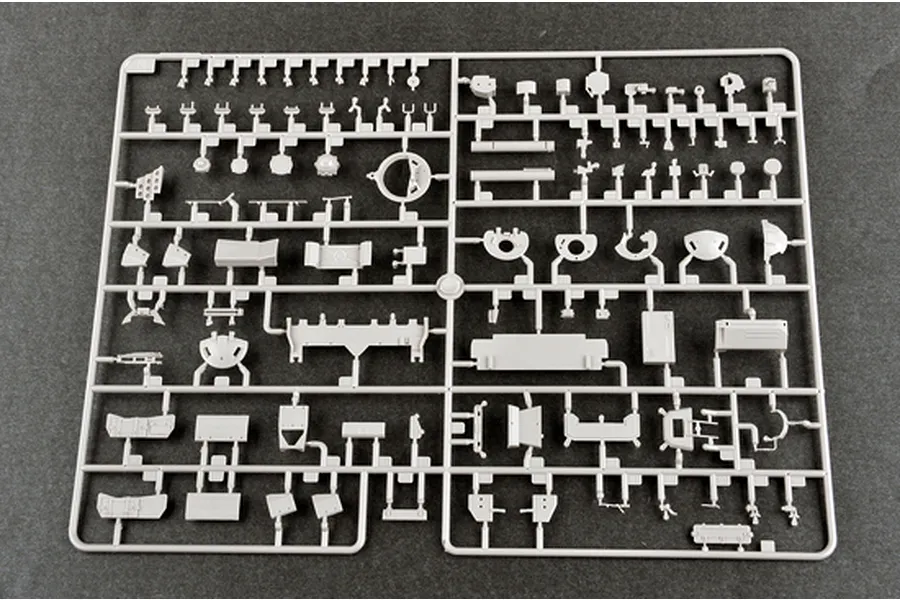 A grey plastic sprue containing various small parts for a 1/35 scale model tank kit, laid out on a dark grey surface.