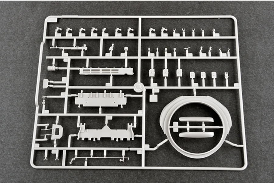 A grey plastic sprue containing various model tank parts, including a turret ring and small components, for a 1/35 scale military model kit.