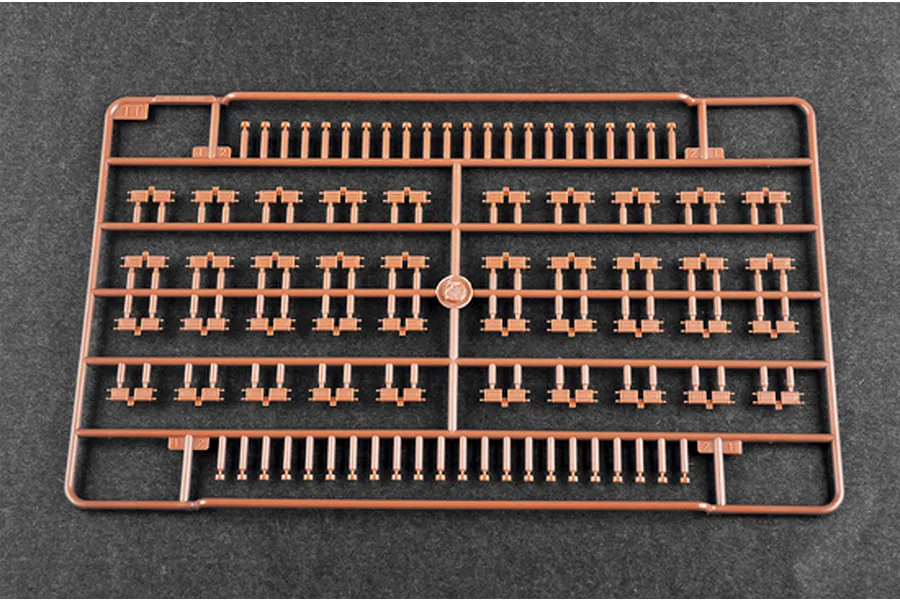 A brown plastic sprue containing numerous small tank track link parts for a 1/35 scale model kit.