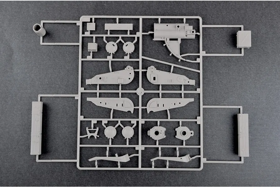A grey plastic sprue containing various model kit parts for a 1/35 scale military vehicle, viewed from directly above against a dark grey background.