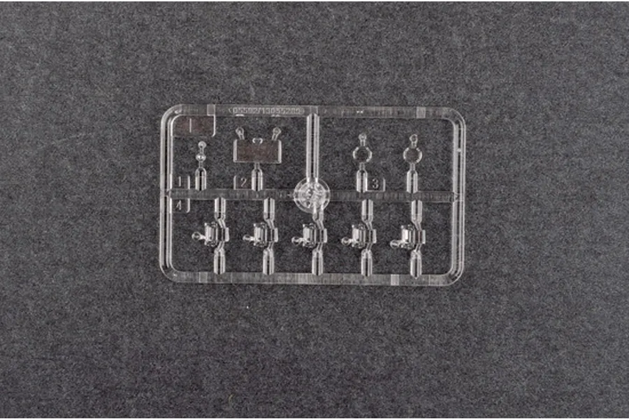A clear plastic sprue containing small transparent parts for a 1/35 scale model kit, set against a dark grey textured background.