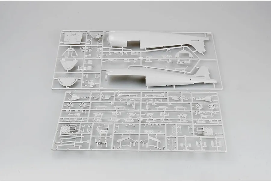 Two grey plastic model kit sprues containing aircraft fuselage halves and various small parts for a 1/32 scale model.
