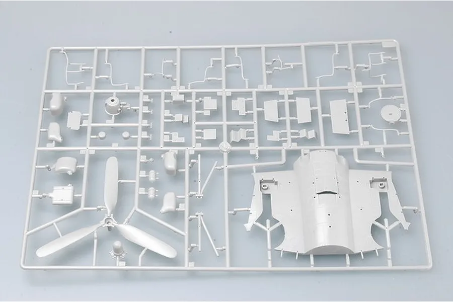 A grey plastic model kit sprue containing various aircraft parts, including a three-blade propeller and fuselage section.