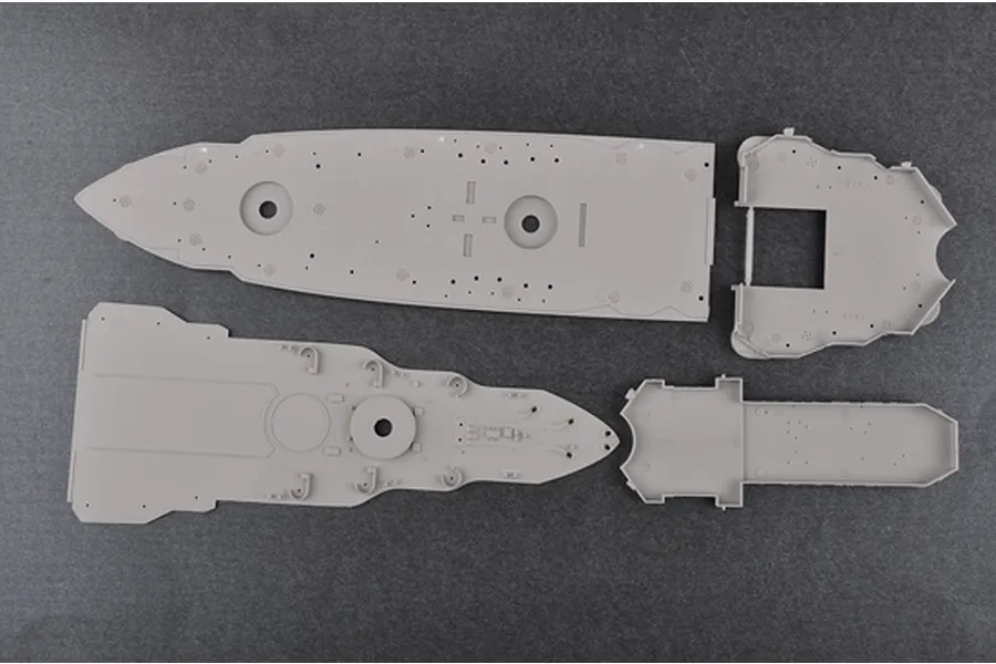 Four grey plastic model ship deck sections from a Trumpeter 1/350 scale model kit laid out on a dark surface.