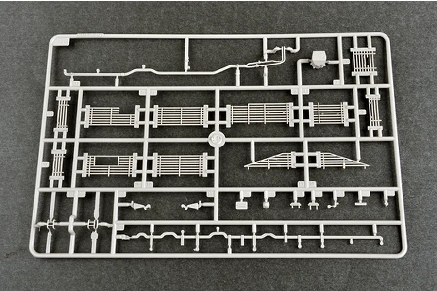 A grey plastic sprue containing various model tank parts, including grille sections and small components, for a 1/35 scale model kit.