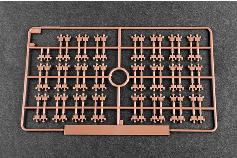 A brown plastic sprue containing multiple small tank track link parts for a 1/35 scale model kit.