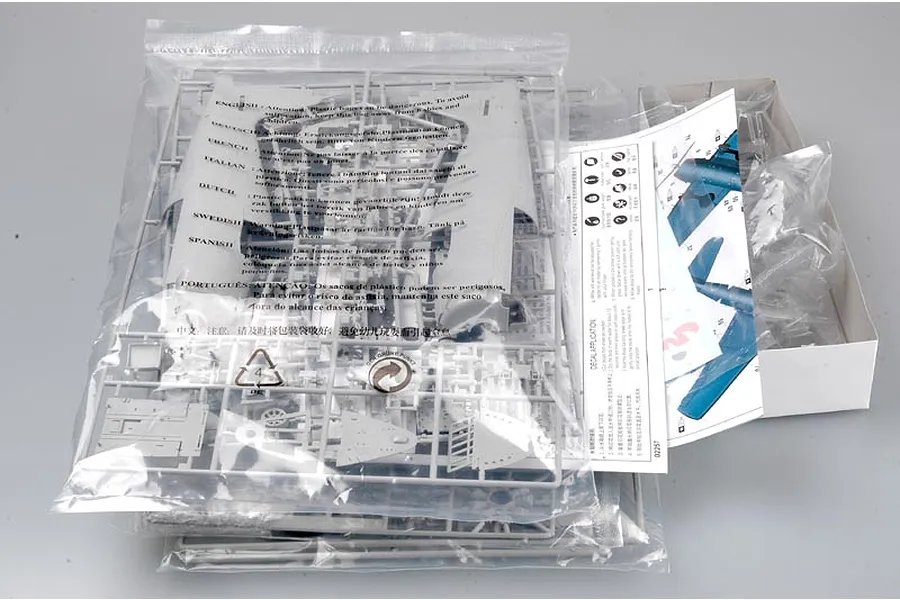Plastic model kit parts for a Trumpeter 1/32 F6F-5 Hellcat in sealed bags with instruction manual inside an open cardboard box.