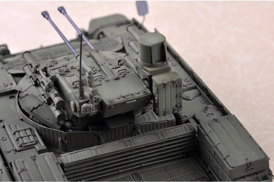 A high-angle close-up of a 1/35 scale model of a BMPT Terminator tank, showing the turret, dual cannons, and olive green hull details.