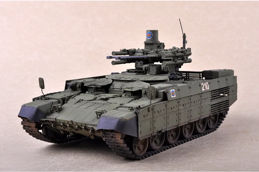 A 1/35 scale plastic model of a BMPT Terminator tank painted in olive green with the number 210 on the side.