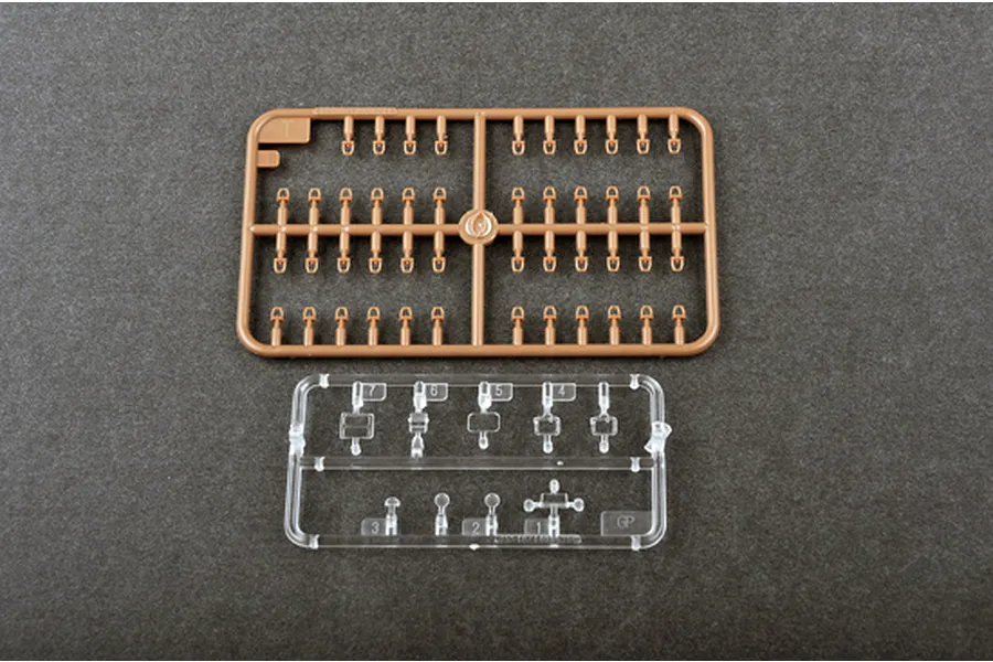 Two plastic model kit sprues, one tan and one clear, on a dark grey background.
