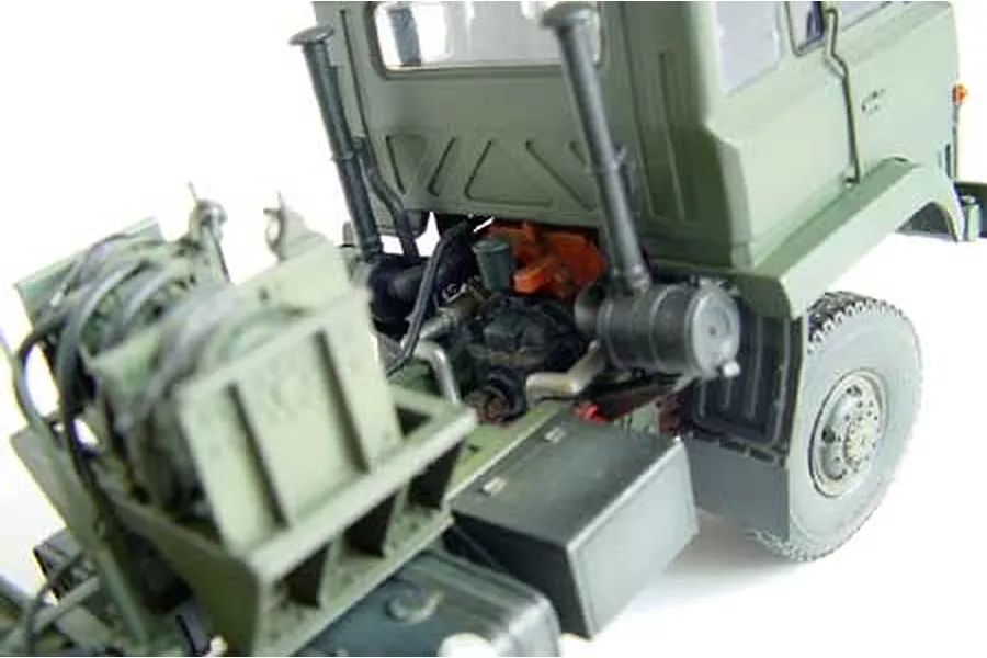 A close-up view of the rear chassis and cabin of a 1/35 scale Chinese 50 Ton Tank Transporter model truck, showing detailed mechanical parts and olive green paint.