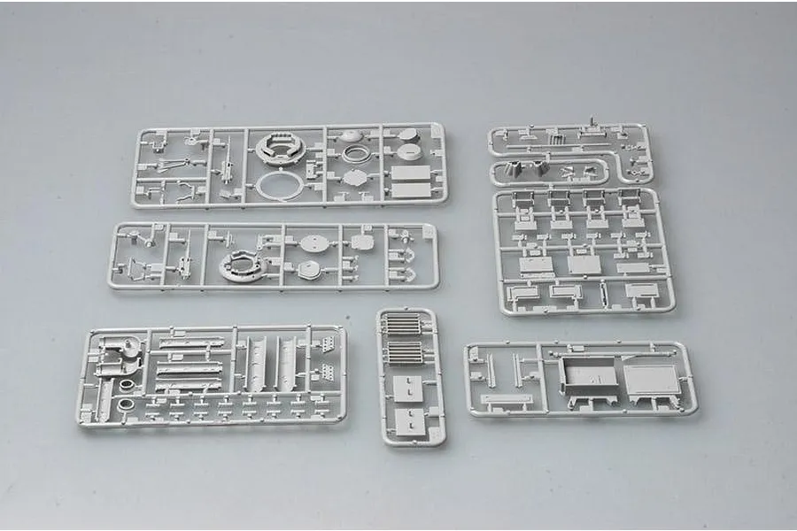 Six grey plastic model kit sprues containing various tank parts laid out on a plain light grey background.
