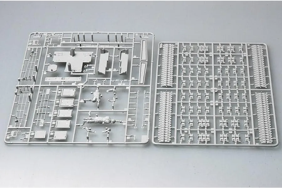 Two grey plastic model kit sprues showing tank parts and a figure on a plain background.