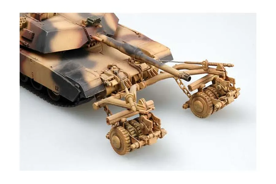 A 1/35 scale model of an M1 Abrams tank equipped with a mine clearing roller system, featuring a desert camouflage paint scheme.
