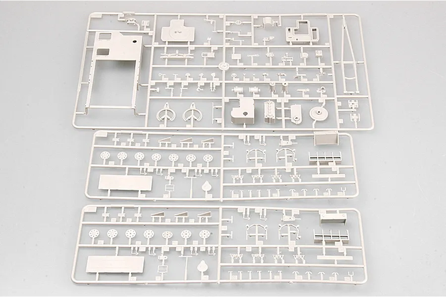 Three grey plastic model kit sprues containing various tank parts laid out on a plain background.