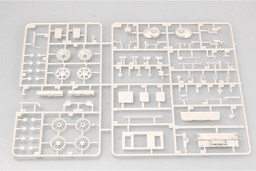 A light grey plastic model kit sprue containing various tank parts, including road wheels, sprockets, and hull components.