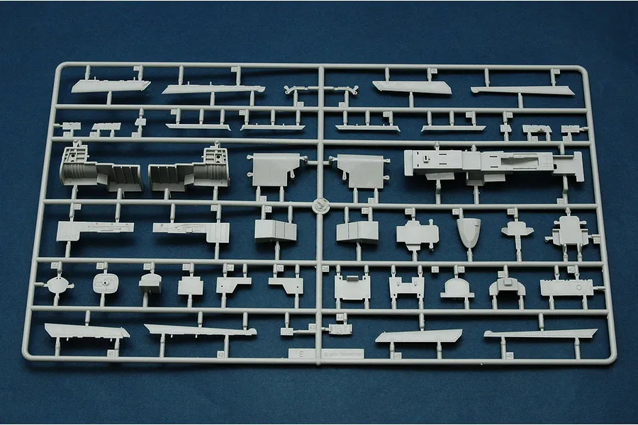 A grey plastic sprue containing various model aircraft parts for a 1/48 scale Trumpeter RA-5C Vigilante kit, set against a dark blue background.