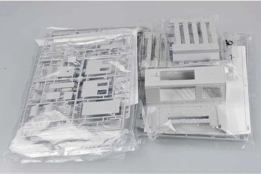 Plastic model kit parts for a Trumpeter 1/35 German WR 360 C12 locomotive, including sprues and body components in clear plastic bags.