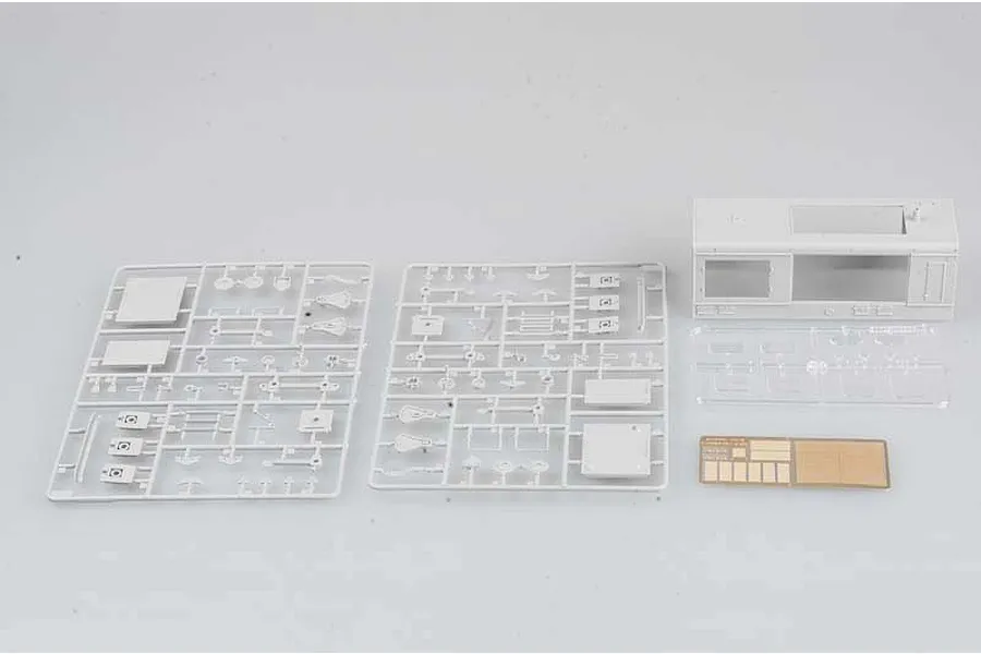 Plastic model kit parts for a 1/35 scale German locomotive, including two grey sprues, a locomotive cabin shell, clear parts, and a photo-etched metal sheet.