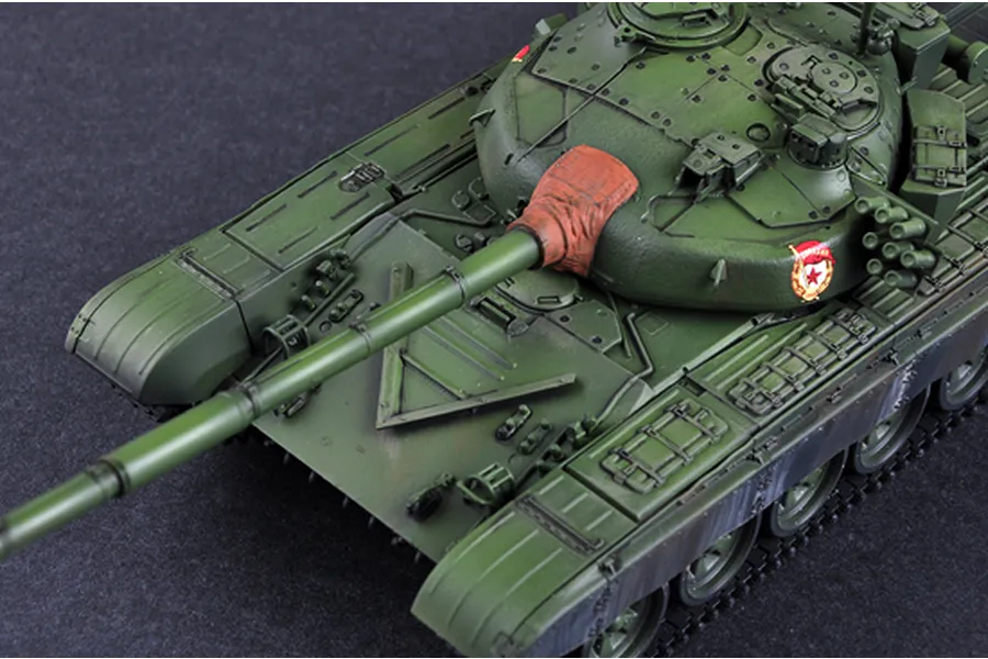 High-angle view of a painted 1/35 scale model of a Russian T-72B tank, showing the turret, main gun, and hull details on a dark surface.